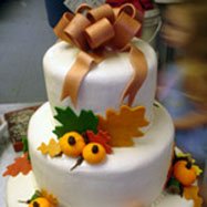 Unique fall theme cake with orange and green leaves.