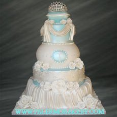 Picture of an elegant white cake with draping and a crystal tiarra.